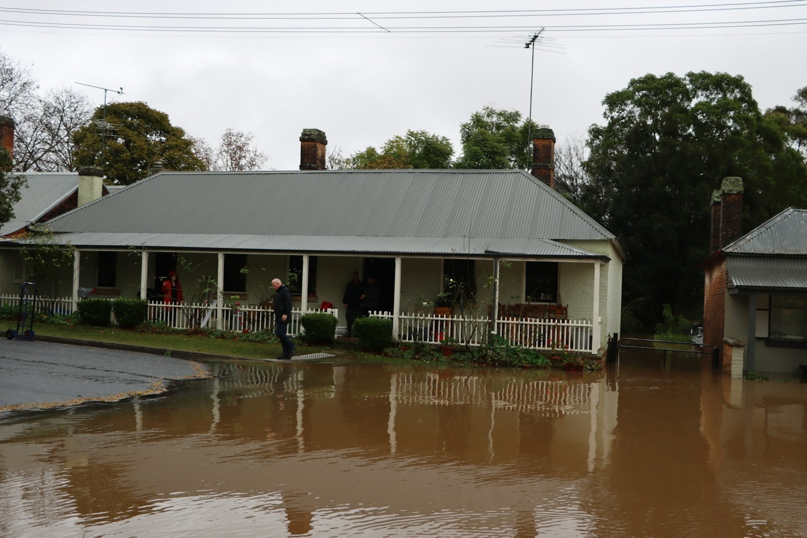House on a street covered by brown floodwater