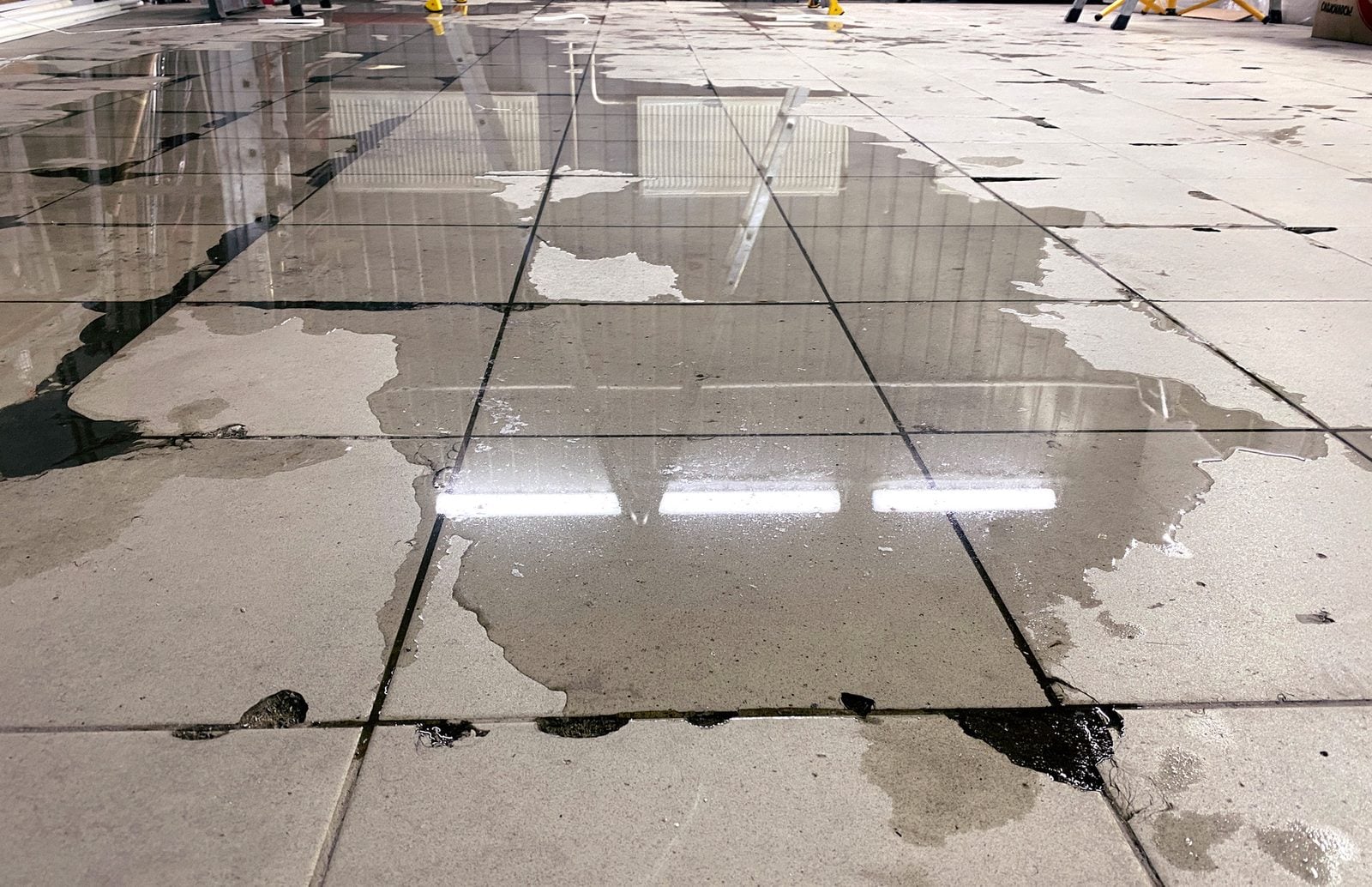 Puddled water covering a tiled floor after a flood